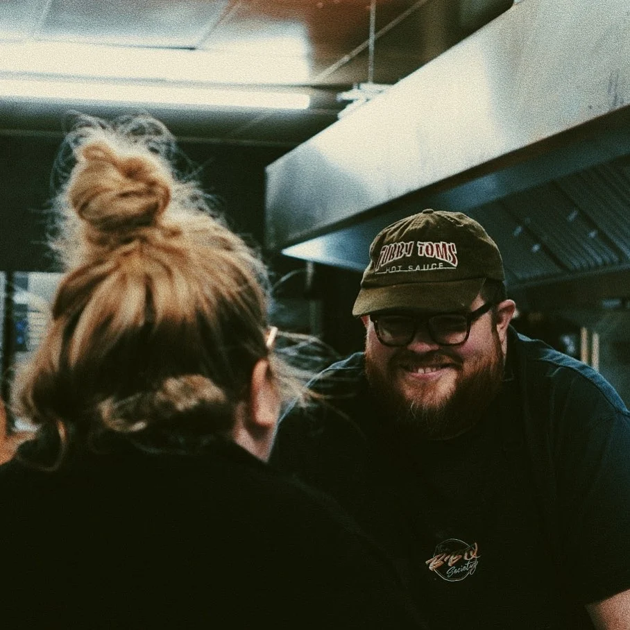 BBQ Society owner, Ben Williams smiling and laughing with his wife, Sophie Williams who is out of shot