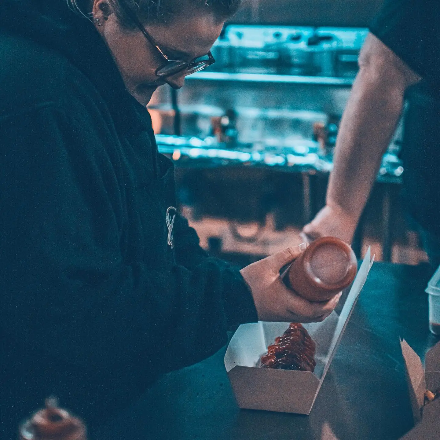 BBQ Society owner, Sophie Williams adding sauce to finish an artisanal hot dog